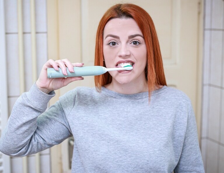 A young woman brushing teeth